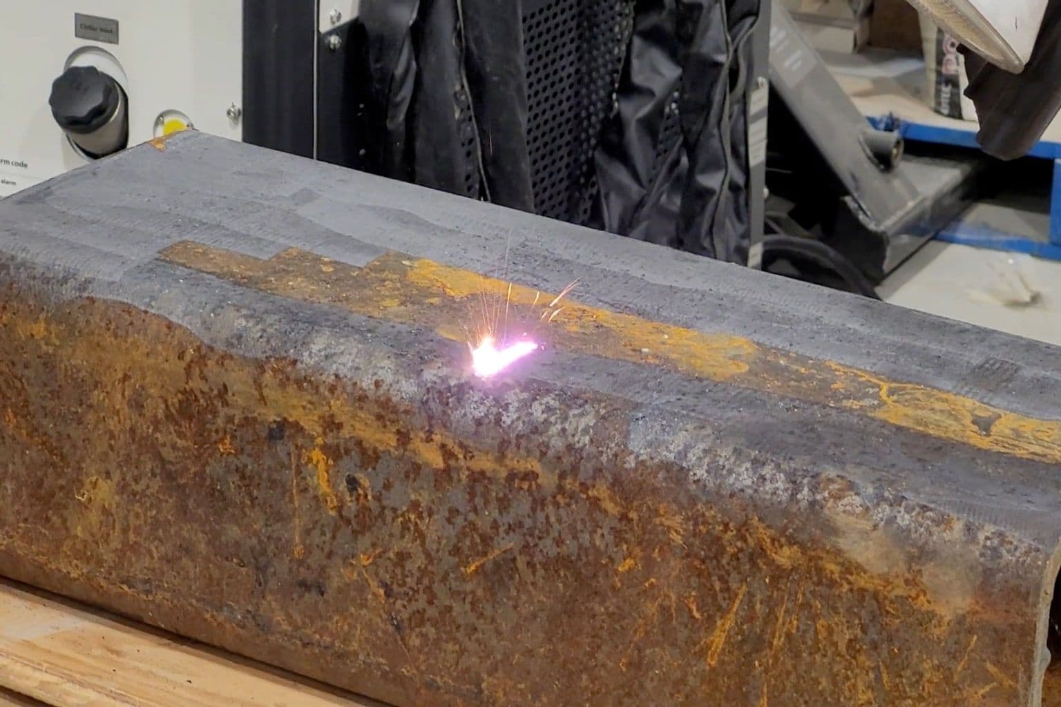 Steel plate half rusted, half laser-cleaned to bare metal